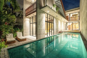 A modern indoor swimming pool with lounge chairs, concrete walls, and a wooden deck. - C La Villa Modern 4br Villa Canggu Beach 5mins (Kerobokan)