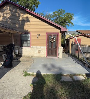 Une maison à deux étages, avec une façade marron, un porche à l’avant et un garage.