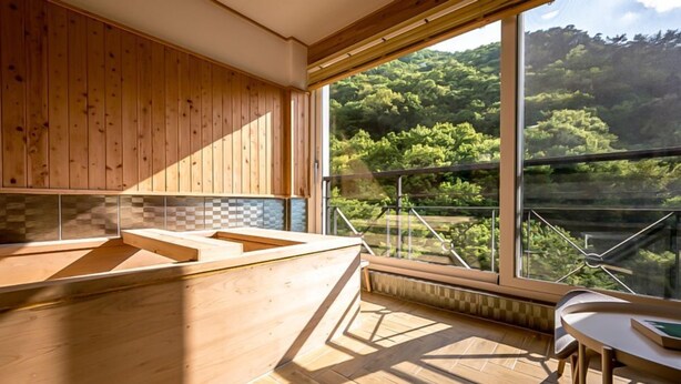 A modern kitchen with wooden cabinets and a large window overlooking a forested area. - Miryang EVERMIRACLE HOTEL (Miryang)