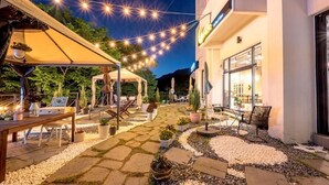 An outdoor patio area with string lights, seating, and potted plants. - Miryang EVERMIRACLE HOTEL (Miryang)