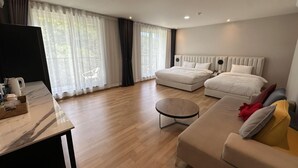 A modern hotel room with two beds, a sofa, a coffee table, and a TV. - Miryang EVERMIRACLE HOTEL (Miryang)