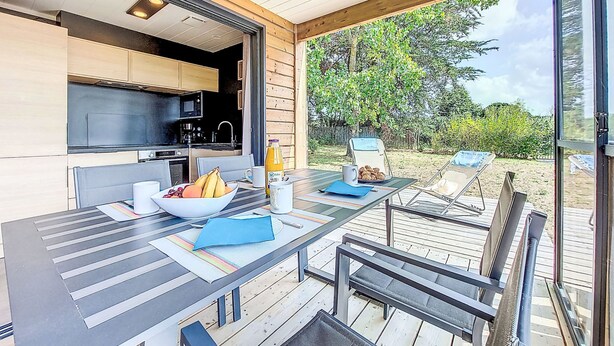 An open-plan kitchen and dining area with a view of the outdoors. - Chalet moderne La Baule-Guérande by Interhome (Guérande)