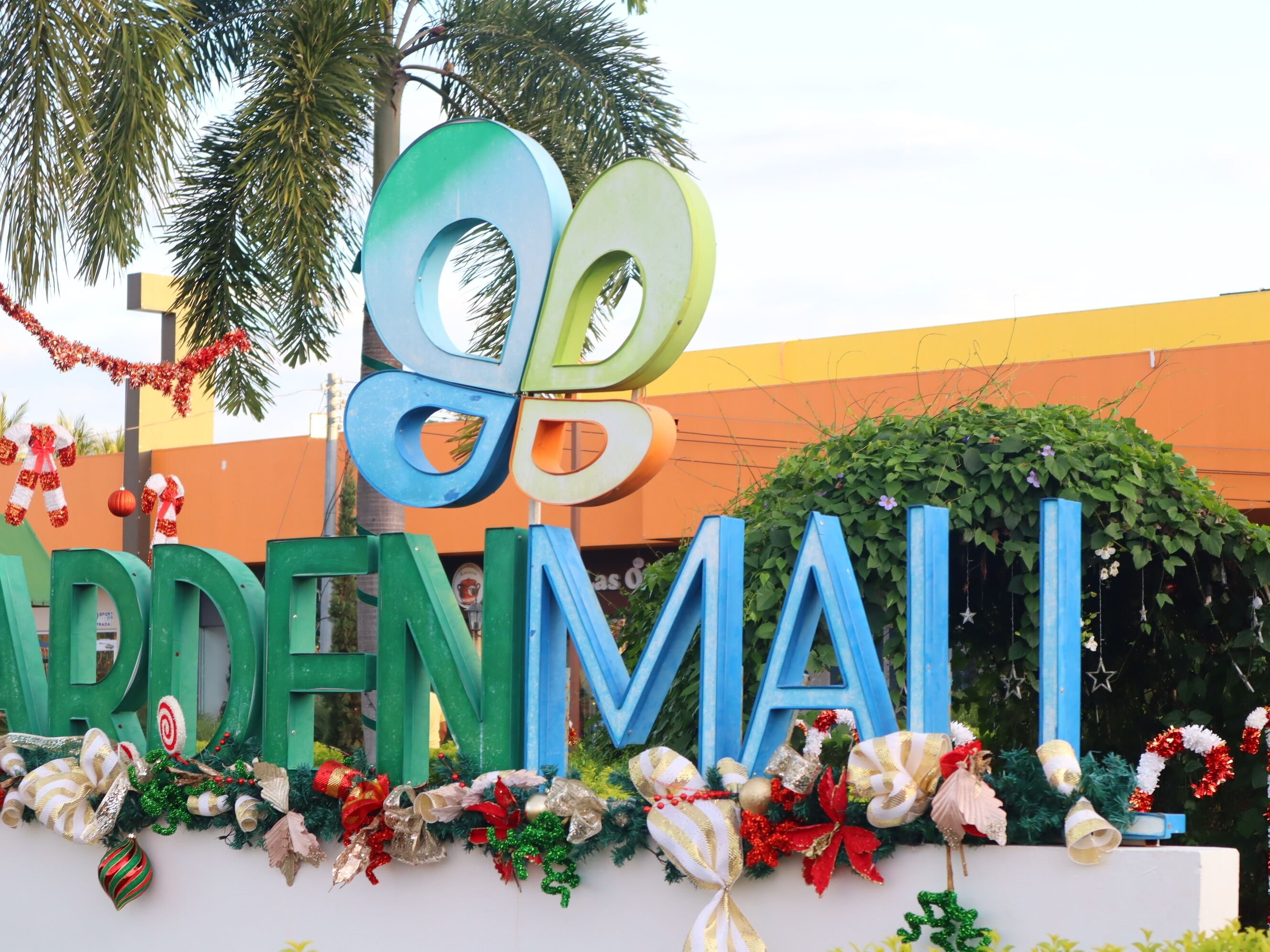 Um letreiro com o texto 'GODDEN MALL' rodeado por decorações festivas.