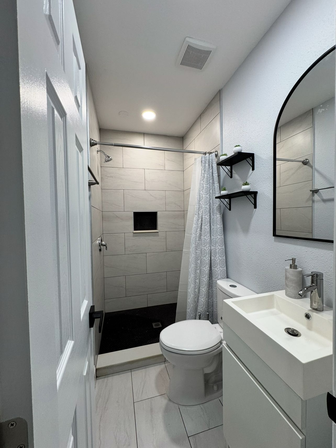 Un baño con inodoro, lavabo y zona de ducha.