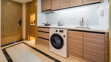 A modern kitchen with wooden cabinets, a built-in washing machine, a sink, and a stove.