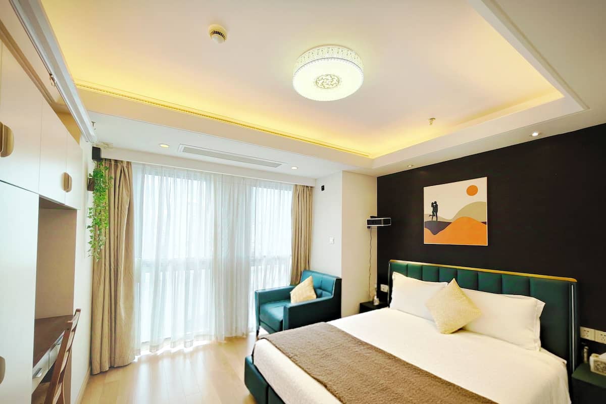 Une chambre d’hôtel moderne, dotée d’un grand lit, d’un bureau et d’une chaise.