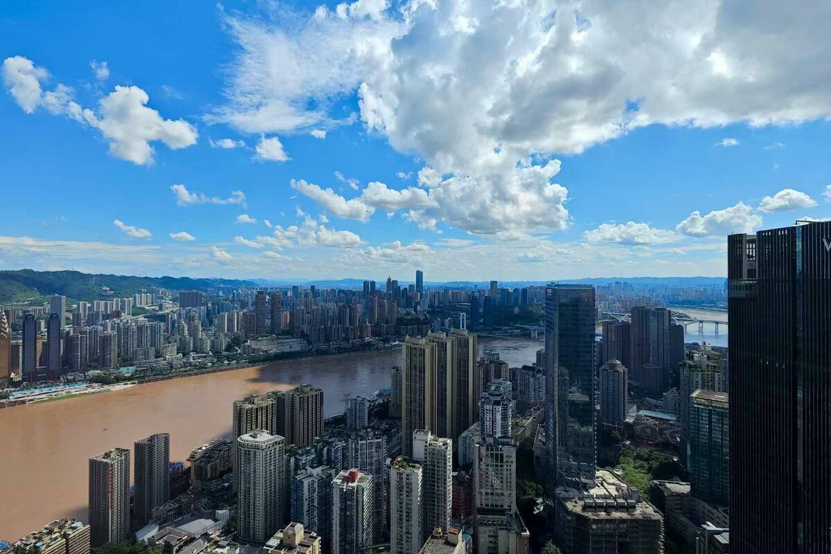 Stadsgezicht met een rivier, hoge wolkenkrabbers en een opvallend 'WESTIN' hotel.