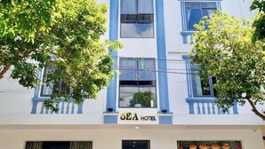 Un hôtel à plusieurs étages, reconnaissable à son grand panneau indiquant « SEA HOTEL ».