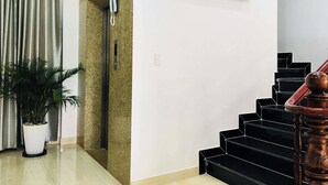 Un escalier avec une rampe en bois et un téléviseur moderne fixé au mur.