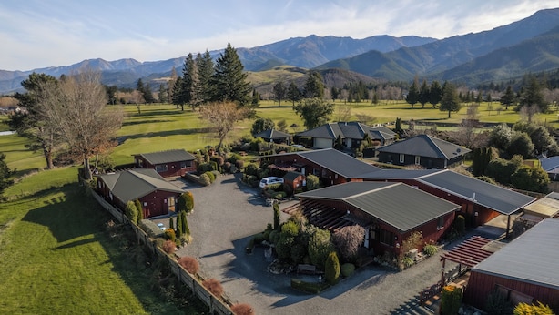 A rural property with multiple cabins, a gravel driveway, and a well-maintained lawn. - Alpine Springs Motel | Unit 5 - HS31215 (Hanmer Springs)
