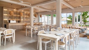 A spacious dining area with high ceilings, natural light, and a view of the outdoors. - Asaya Sands (Mirissa)