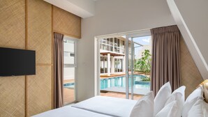 A hotel room with a bed, a TV, a sliding glass door to a pool area. - Asaya Sands (Mirissa)