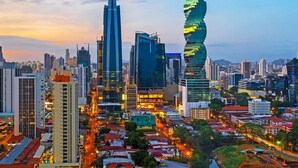 Un paisaje urbano con rascacielos modernos, incluyendo una torre distintiva en espiral, y una red de calles y edificios.