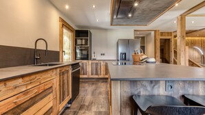 A modern kitchen with wooden cabinetry, a central island, and a built-in oven.