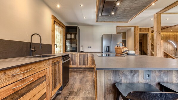A modern kitchen with wooden cabinetry, a central island, and a built-in oven.
