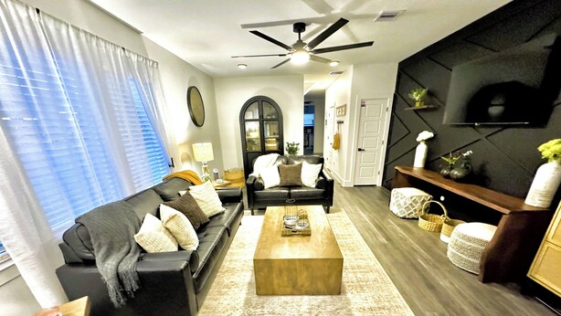 A modern living room with a sofa, coffee table, and seating area. - The Mini Mansion on Main Street (La Porte)