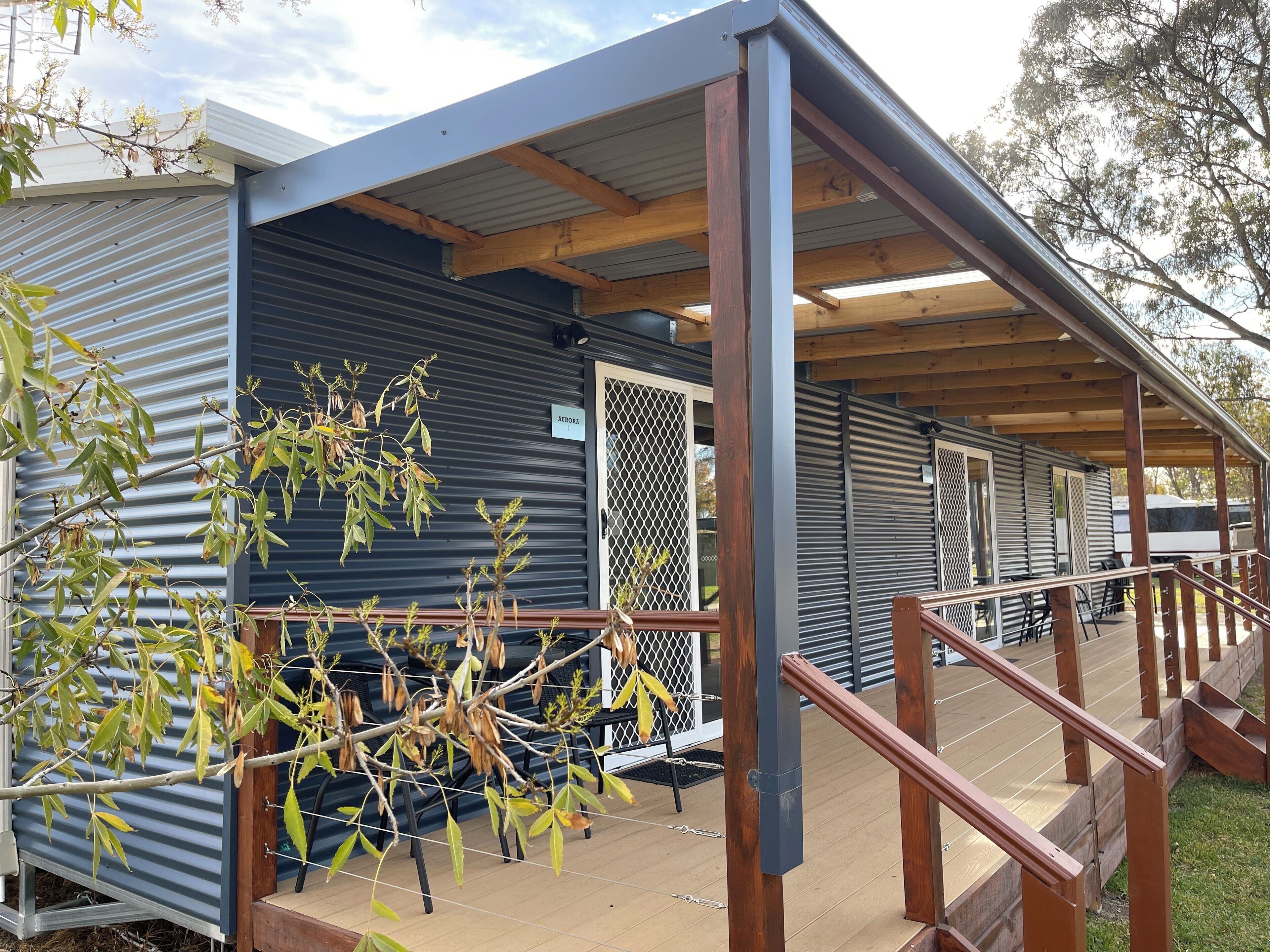 A covered outdoor area with a wooden deck and metal railings.