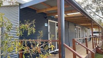 A covered outdoor area with a wooden deck and metal railings.