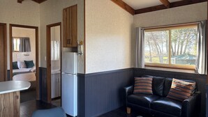 Una habitación compacta con kitchenette, zona de comedor y sala de estar con sofá y ventana con vistas.
