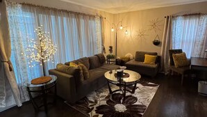 A living room with a sofa, two armchairs, a coffee table, and a floor lamp. - Cozy Single-family house (Glendale)