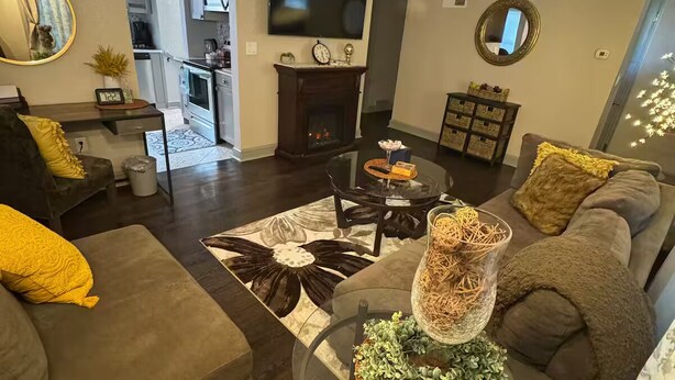 A modern living room with a fireplace, a television, and a dining area. - Cozy Single-family house (Glendale)