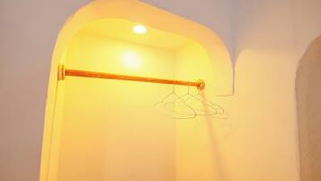 A room with a wooden towel rack and a hanging clothes rack.