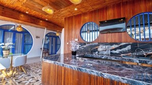 A reception area with a wooden ceiling, a marble counter, and blue-framed windows. - Anny Guesthouse 2 by Ecommerceloka (Denpasar)