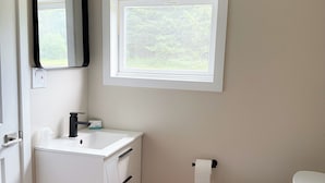 A bathroom with a white sink, mirror, and toilet.