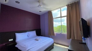 A hotel room with a bed, a TV, a window with curtains, and a view of the outdoors. - Collection O KLIA Formerly Bary Inn. (Sepang)