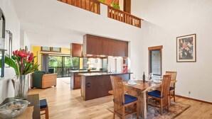 A spacious living area with a dining table, chairs, and a kitchen island. - Waikomo Stream Villas 430 – End Residence, Full A/C, Streamside (Koloa)