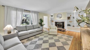 Una sala de estar con un sofá, un sillón y una chimenea.