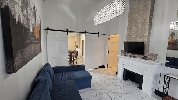 A living room with a blue sofa, a fireplace, and a television mounted above it.