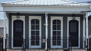 A building with a white facade, black-framed windows, and a metal roof.