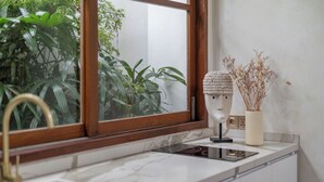 A kitchen with a window, sink, and countertop. - Villa BUMI - Designer Villa 10 min to the Beach (Bali)