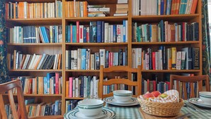 A room with a checkered tablecloth, a dining set, and a bookshelf filled with books. - 4 bedroom accommodation in Thornton Watlass, near Masham (Thornton Watlass, near Masham)