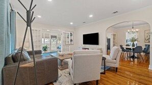 A modern living room with a sofa, armchair, and dining table.