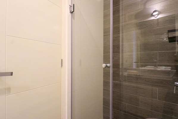 A modern bathroom with a glass shower enclosure, a white tiled wall, and a wooden floor. - w Prestigious 3BR w Great Balcony in Miraflores (Lima)
