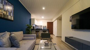 A modern living room with a sofa, a glass coffee table, and a TV mounted on the wall. - w Glorious 2BR w Balcony in San Isidro (Lima)