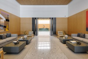 A modern lobby with a reception desk, two sofas, and a coffee table. - w Luxurious 1BR w/ Amazing View in Cuauhtémoc (Mexico City)