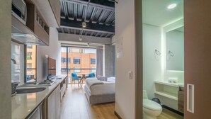 A modern kitchen with a built-in microwave and a dining area with a table and chairs. - w Dreamy 2BR in Parque Virrey (Bogotá)