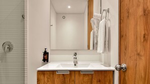 A bathroom with a white sink, wooden vanity, and a mirror. - W Amazing 1BR w Beautiful View in Virrey (Bogotá)