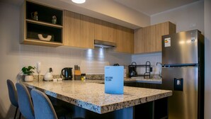 A modern kitchen with granite countertops, stainless steel appliances, and wooden cabinetry. - w Great 1BR Apartment in Miraflores (Lima)