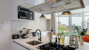 Une cuisine moderne équipée d’une cuisinière intégrée, d’un four à micro-ondes et d’une grande fenêtre donnant sur la ville.