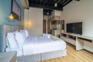 A modern bedroom with a large bed, a television, and a kitchenette area. - w Wonderful 2BR in Parque Virrey (Bogotá)