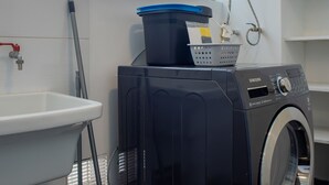 A laundry area with a washing machine, a sink, and a mop. - w Stunning 3BR in Miraflores (Lima)