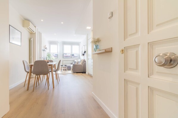 A modern living room with a sofa, a dining table with chairs, and a kitchen area in the background. - w Remarkable 1BR With Lovely Decor in Justicia (Madrid)
