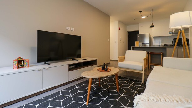 A modern living room with a flat-screen TV, a small table, and a sofa. - w Captivating 1BR w Perfect Terrace in Cusco (Cusco)