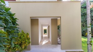 Un edificio moderno con diseño minimalista, que presenta un camino central que conduce a una escalera.