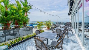 An outdoor patio with tables and chairs, a pool, and potted plants. - w Awesome 1BR w Great Deco in Avenida Balboa (Panama City)