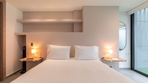 A modern hotel room with a large bed, two bedside tables with lamps, a built-in shelf, and a large window offering a view. - w Spacious 3BR w Outdoor Dining Terrace in Laureles (Medellín)